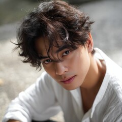Poster - A man with brown hair and brown eyes is sitting on the ground in a white shirt