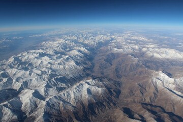 Poster - Expansive view of snow-capped mountains under a clear blue sky at high altitude