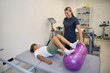 © Svitlana - Teenage boy practices leg movements on therapy table