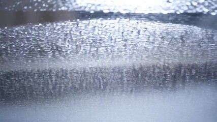 Poster - Abstract background of blurry droplets clinging on a window pane, shimmering and reflecting light, creating a textured surface with an organic feel.