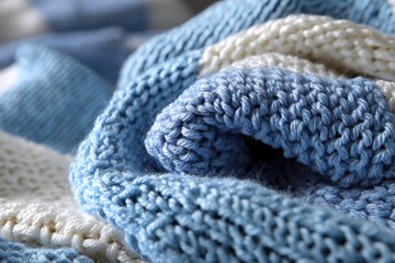 Poster - Soft blue knitted fabric displayed on a textured surface for cozy winter warmth during the day