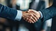 © An - Two business men shaking hands in an office setting.