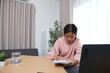 © Wichayada - A girl is sitting at a desk with a laptop and a notebook