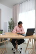 © Wichayada - A girl is sitting at a desk with a laptop and a notebook