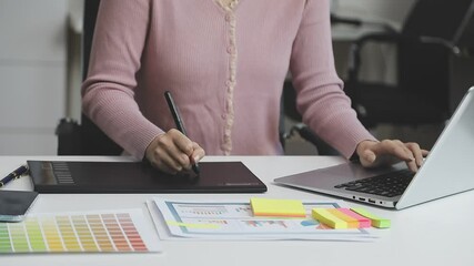 UX/UI designer working on wireframes for a website and mobile app prototype, surrounded by sketches of user-flow and design tools, in concept of website and mobile application design concept.