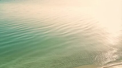 Poster - Aqua tinted water ripples under sunlight and subtle coastal waves flowing onto sandy shore