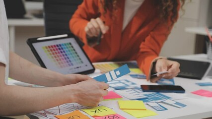 UX/UI designer working on wireframes for a website and mobile app prototype, surrounded by sketches of user-flow and design tools, in concept of website and mobile application design concept.