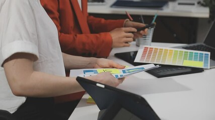 UX/UI designer working on wireframes for a website and mobile app prototype, surrounded by sketches of user-flow and design tools, in concept of website and mobile application design concept.