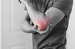 © kieferpix - Man with elbow injury showing red highlights pain relief concept concept muscle pain due to lateral epicondylitis or tennis elbow injury, Health care concept