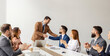 © Dusan Petkovic - Friendly executive shaking hands and congratulating his associate for business success while team clapping hands.