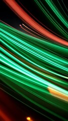 Poster - Abstract glowing lines of orange and green light trails against a black background, creating a dynamic and modern futuristic visual.