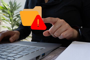 Poster - Businesswoman working on computer, pointing at a folder icon with a warning sign