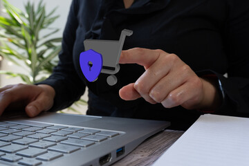 Poster - Businesswoman working on computer, pointing at a 3D icon of a supermarket cart with a shield