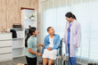 © Rakchanok - Senior woman in wheelchair receiving supportive visit from younger family member while doctor observes, symbolizing care, connection, and emotional bonding in medical environment, healthcare.