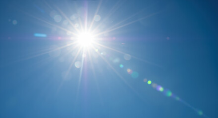 bright sun with radiating rays against clear deep blue sky with lens flare effect. natural summer ph