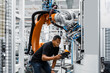 © Westend61 - Engineer operating robotic arm in electrical factory