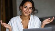 © Evon J - Young hispanic female smiling while sitting at a laptop in casual attire