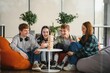 © Serhii - Happy friends playing wooden block tower game at home