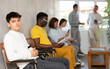© JackF - Casual young guy sitting at hall of civil service building, waiting to speak with representative of immigration office