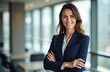 © Vadym - Smiling businesswoman stands arms crossed. Corporate pro in navy blue business suit in office. Successful female boss looks at camera. Confident happy woman leader.