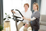 Senior woman doing exercise on bike simulator to keep her health and recovery after trauma