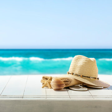 Summer composition on wooden pier on sandy beach with blue sea and sky background. Copy space for product or text.