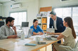 © whyframeshot - Asia strategist leader presents a financial and agile strategy plan to the team in a modern office, leading a collaborative brainstorming session to align goals, boost productivity, and ensure success