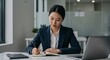 © AlfaSmart - Focused businesswoman writing in office environment
