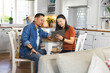 © Wavebreak Media - Mature Asian couple using tablet together at home, discussing plans in kitchen