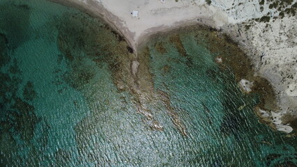   Aerial View of a Tranquil Turquoise Coastline with Rocky Cliffs and Sandy Beach