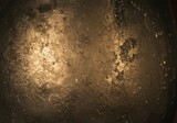 Dark textured background with scratches and bright light reflection, creating a vintage grunge artistic texture with intense warm tones.