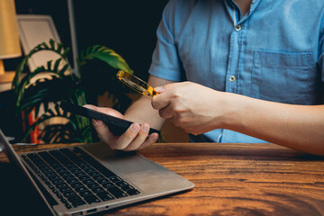 Poster - Person Using Smartphone with Magnifying Glass While Working on Laptop in Cozy Indoor Workspace