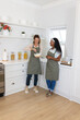 © Wavebreak Media - Whisking batter diverse female friends working at kitchen countertop, with glass mixing bowl
