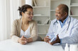 © Anastasiya - Black Doctor Man Showing Clipboard With Test Results To Curious Female Patient, Professional Male Therapist Explaining Medical Therapy Process To Young Woman During Appointment In Office, Closeup