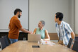 © Wavebreak Media - Shaking hands Diverse coworkers negotiating deal in modern meeting room, with laptop and documents