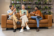 © Wavebreak Media - Discussing diverse coworkers chatting on leather couch at office lounge, with smartphone