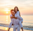 © Metehan - Young cheerful happy couple two friends family man woman in white clothes boyfriend give piggyback ride to joyful, girlfriend sit on back at sunrise over sea beach ocean outdoor seaside in summer day