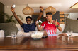 © Wavebreak Media - Cheering diverse male friends gaming on couch in living room, holding wireless controllers