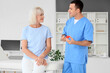 © Pixel-Shot - Male endocrinologist showing thyroid gland model to mature woman in clinic