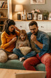© La Famiglia - Family watching suspense movie on tv eating popcorn at home