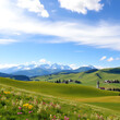 © John - Scenic panoramic view of idyllic rolling hills landscape with blooming meadows and snowcapped alpine mountain peaks in the background on a beautiful sunny day with blue sky and clouds in springtime