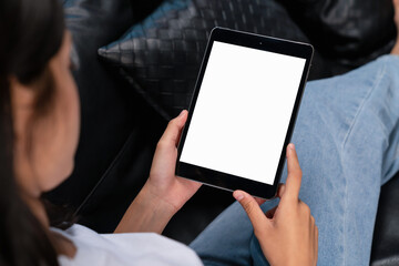 hand holding digital tablet with blank screen for graphic display montage on the sofa in the living 
