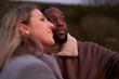 © Christina - Happy couple in warm clothing outdoors at dusk