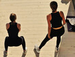 © Diego - Dos mujeres haciendo deporte, yoga y actividad física saludable al aire libre bajo el sol con ropa negra deportiva