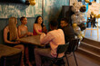 © Christina - Smiling friends talking at table during New Years Eve party