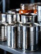 © WACHI - A variety of metal food cans and glass jars are neatly arranged on a pantry shelf.
