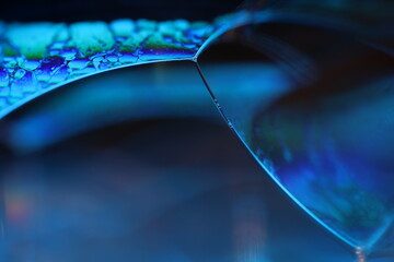 Poster - Bright rainbow spots of liquid on black background, blue colours, surrealistic pattern, fantastic smooth movement