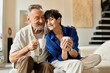 © LIGHTFIELD STUDIOS - Happy middle aged couple enjoying coffee together at home in serene afternoon setting