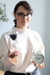© Andrii Zastrozhnov - Young caucasian female with hourglass and clock symbolizing time management