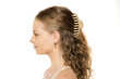 © vladimirfloyd - Side profile of young woman with wavy hair partially secured with beige hair claw clip, wearing white tank top against clean background, showing natural beauty